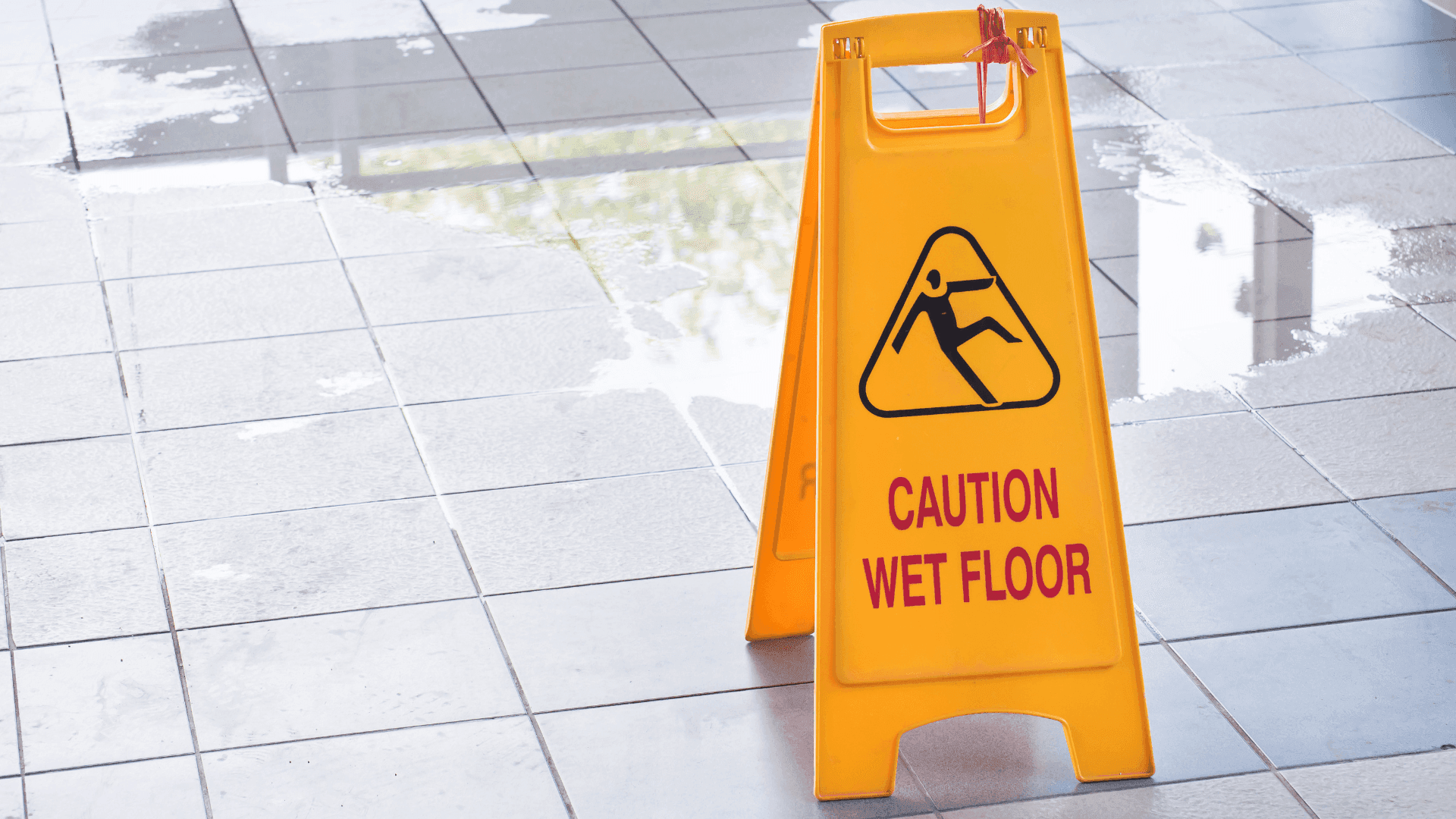 Yellow caution wet floor sign warning customers of a slippery floor in a public building, illustrating duty of care in a personal injury case.