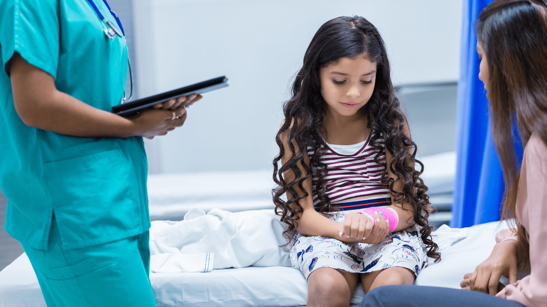 Young girl with an injured wrist sitting beside her parent in a hospital exam room, illustrating a child personal injury claim.