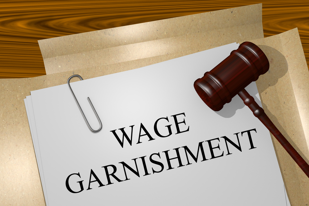 Papaer with wage garnishment wriiten on it with a gavel