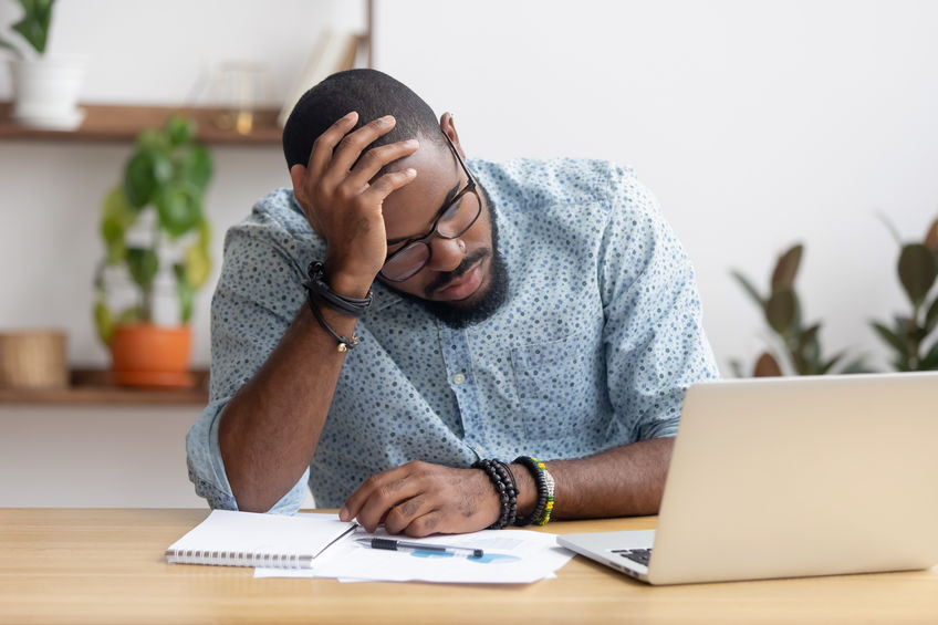 Tired depressed bored african businessman frustrated by debt