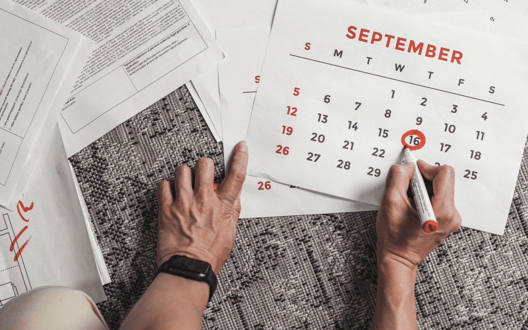 Person circling a date on a calendar beside paperwork, representing the importance of the date last insured in an SSDI claim.